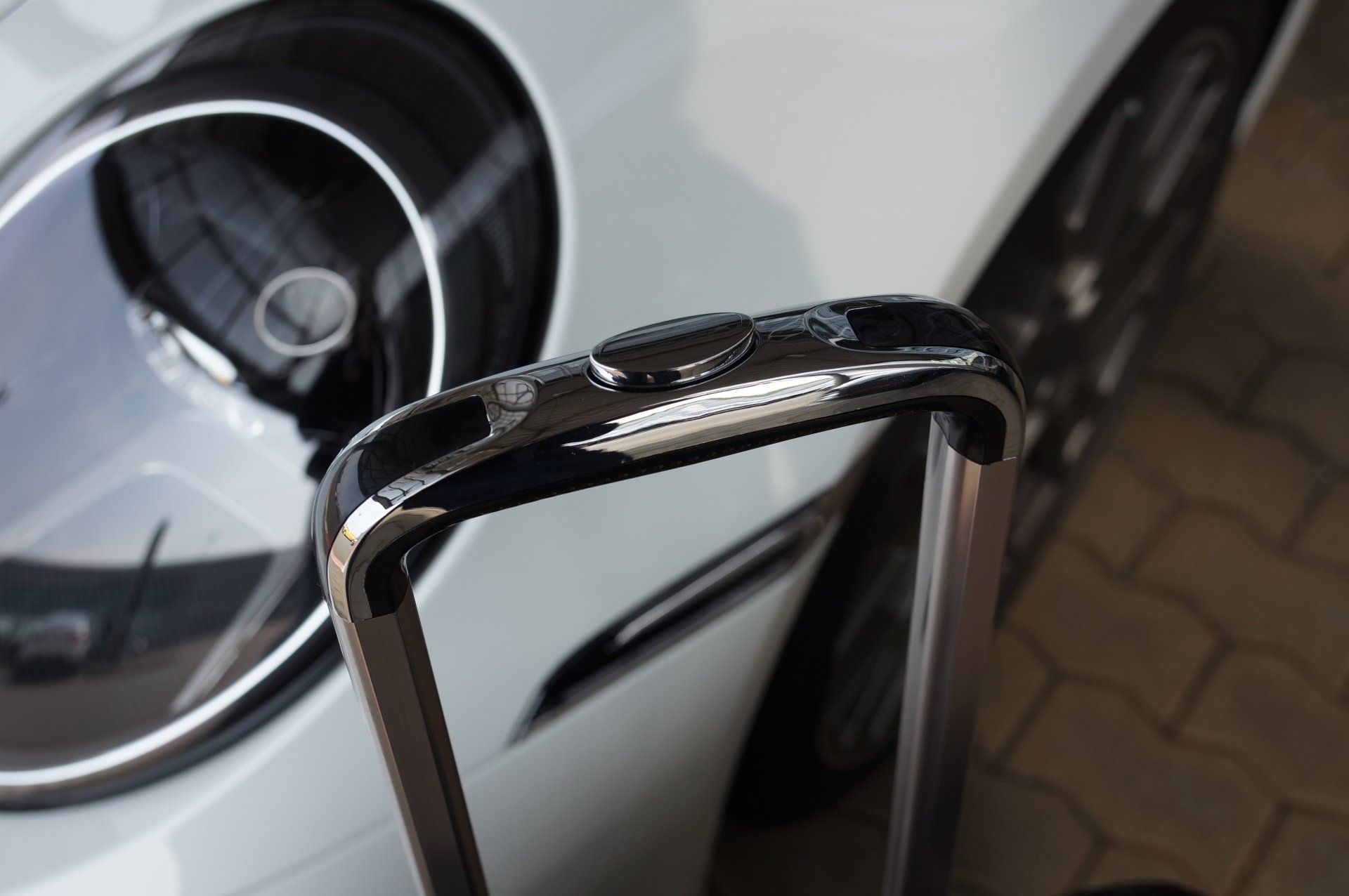 Een koffer staat voor een witte auto