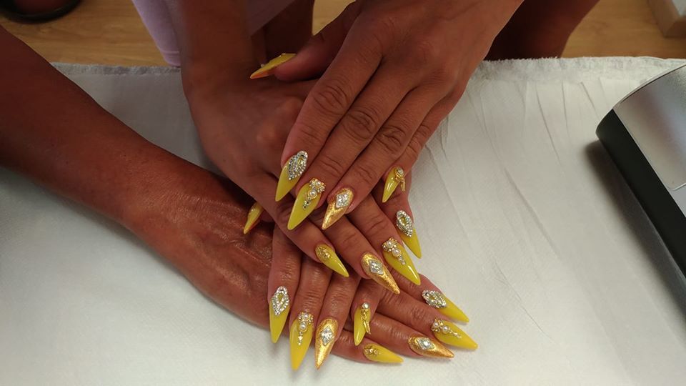 Manicure con smalto giallo e unghie a mandorla