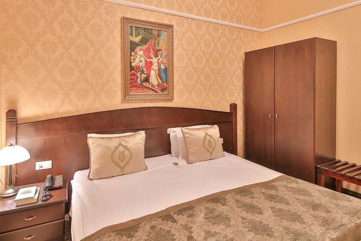 A hotel room with a bed and a painting on the wall