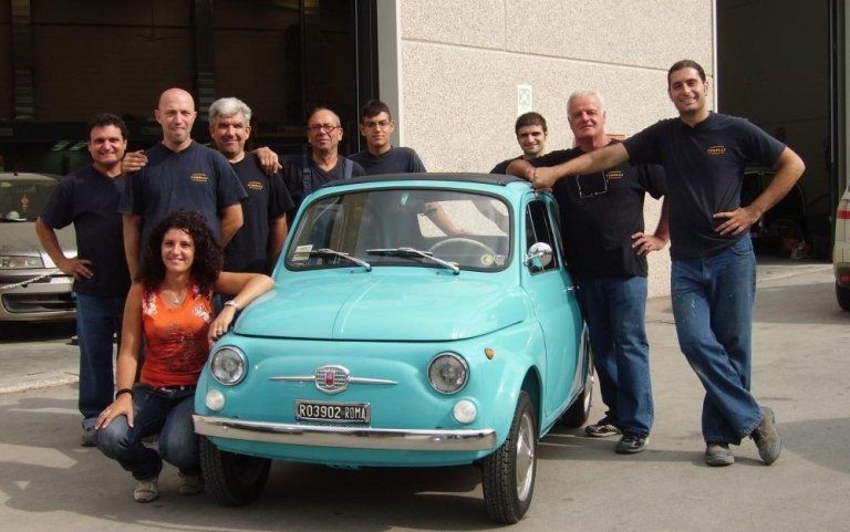 team di meccanici davanti ad autofficina