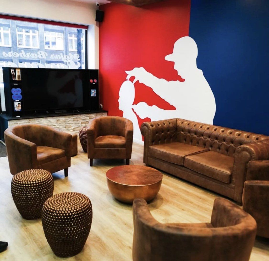 Ein Wohnzimmer mit einer Couch und Stühlen und einer Silhouette eines Mannes an der Wand