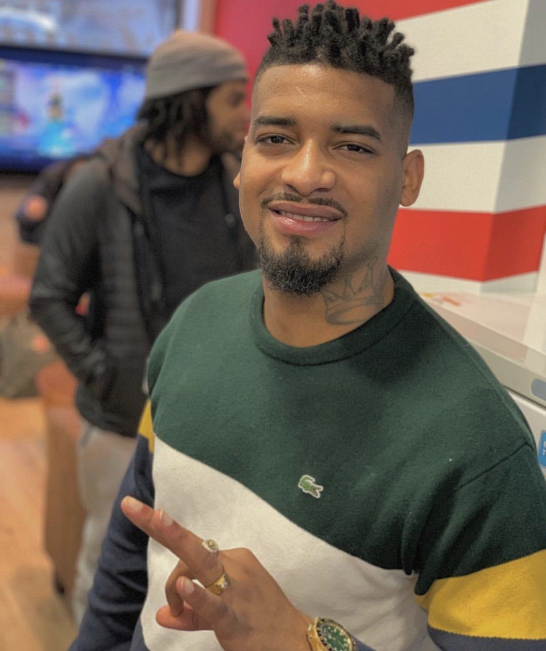 Ein Mann, der einen Pullover mit einem Lacoste-Logo trägt