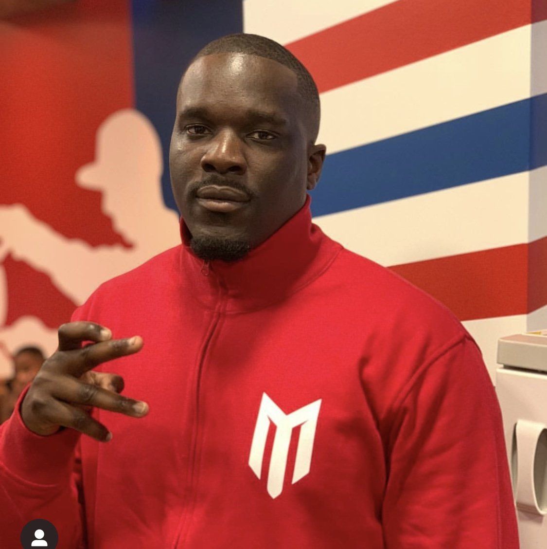 Ein Mann, der eine rote Jacke mit dem Buchstaben M darauf trägt