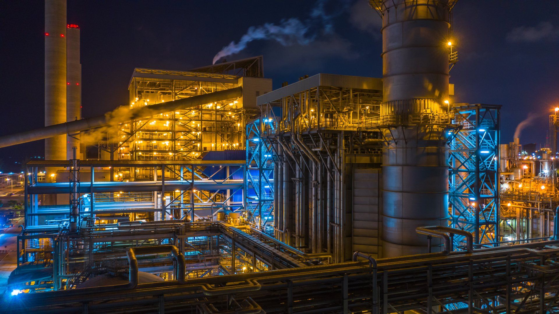 A large industrial plant is lit up at night.