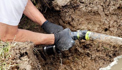 technician at work on septic system in the ground