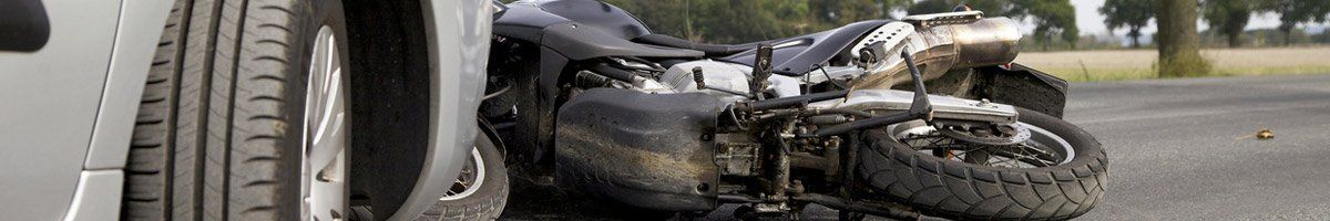 motorcycle laying on road behind car