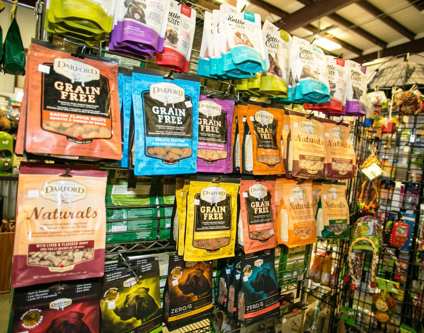 Colorful pet food bags stacked on store shelves in a grocery aisle
