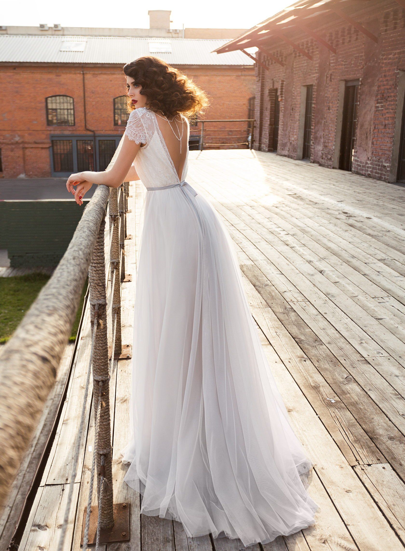 Eine Frau in einem Brautkleid steht auf einer Holzbrücke.