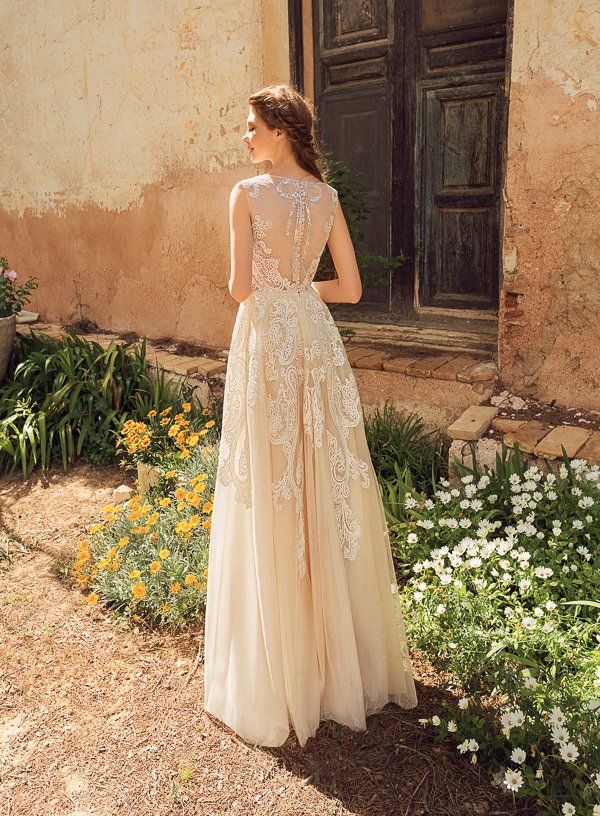 Eine Frau in einem Brautkleid steht vor einer Tür in einem Garten.