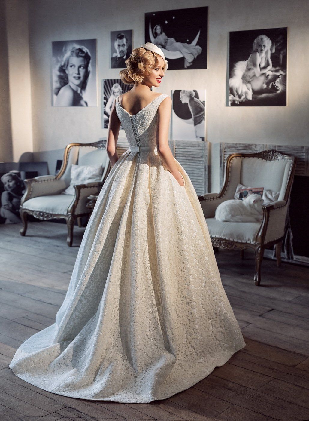 Eine Frau in einem Brautkleid steht in einem Raum mit Bildern an der Wand.