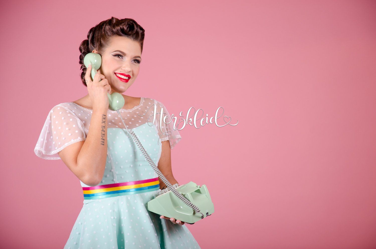 Eine Frau in einem blauen Kleid telefoniert mit einem grünen Telefon.