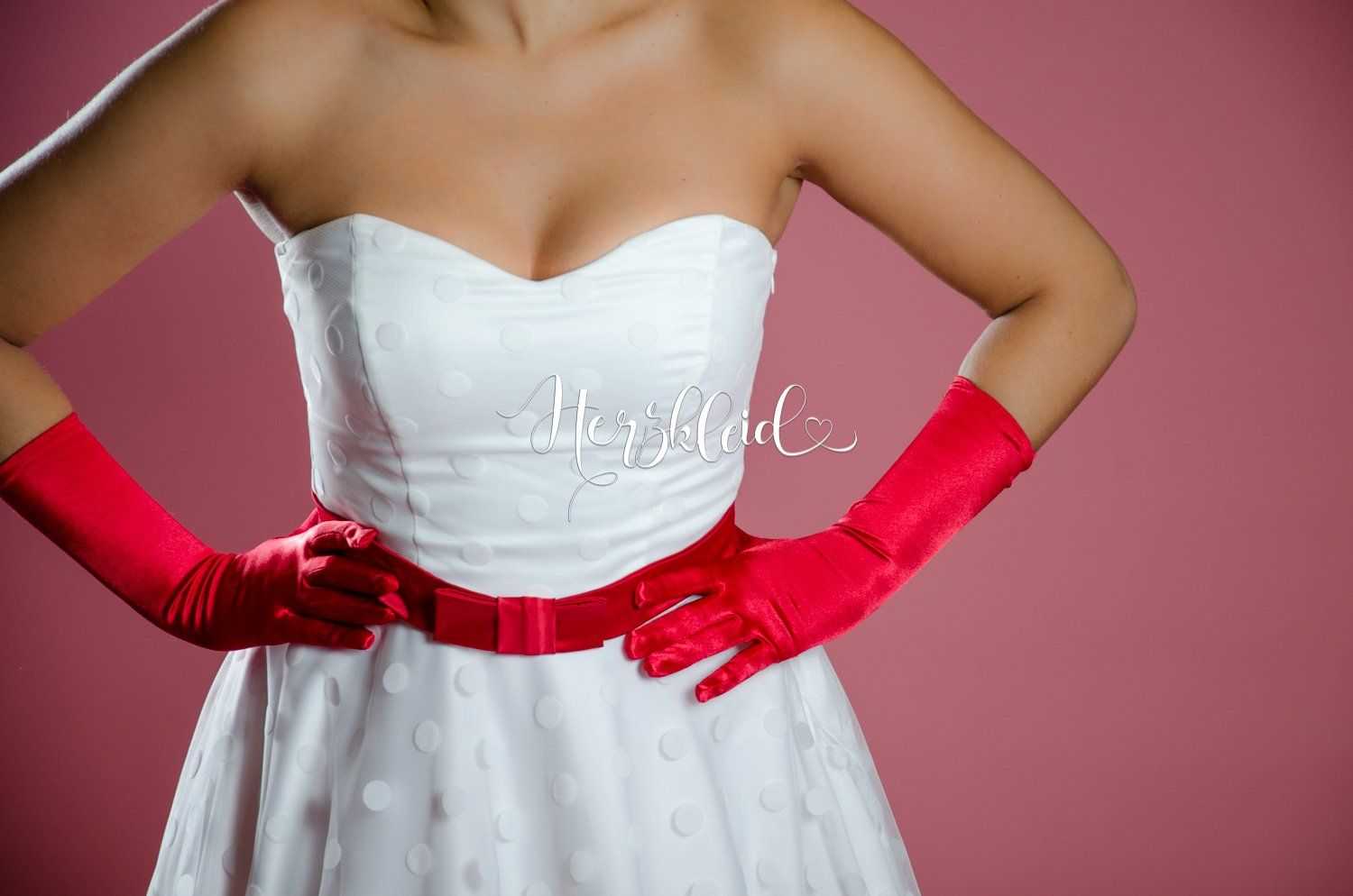 Eine Frau in einem weißen Kleid und roten Handschuhen