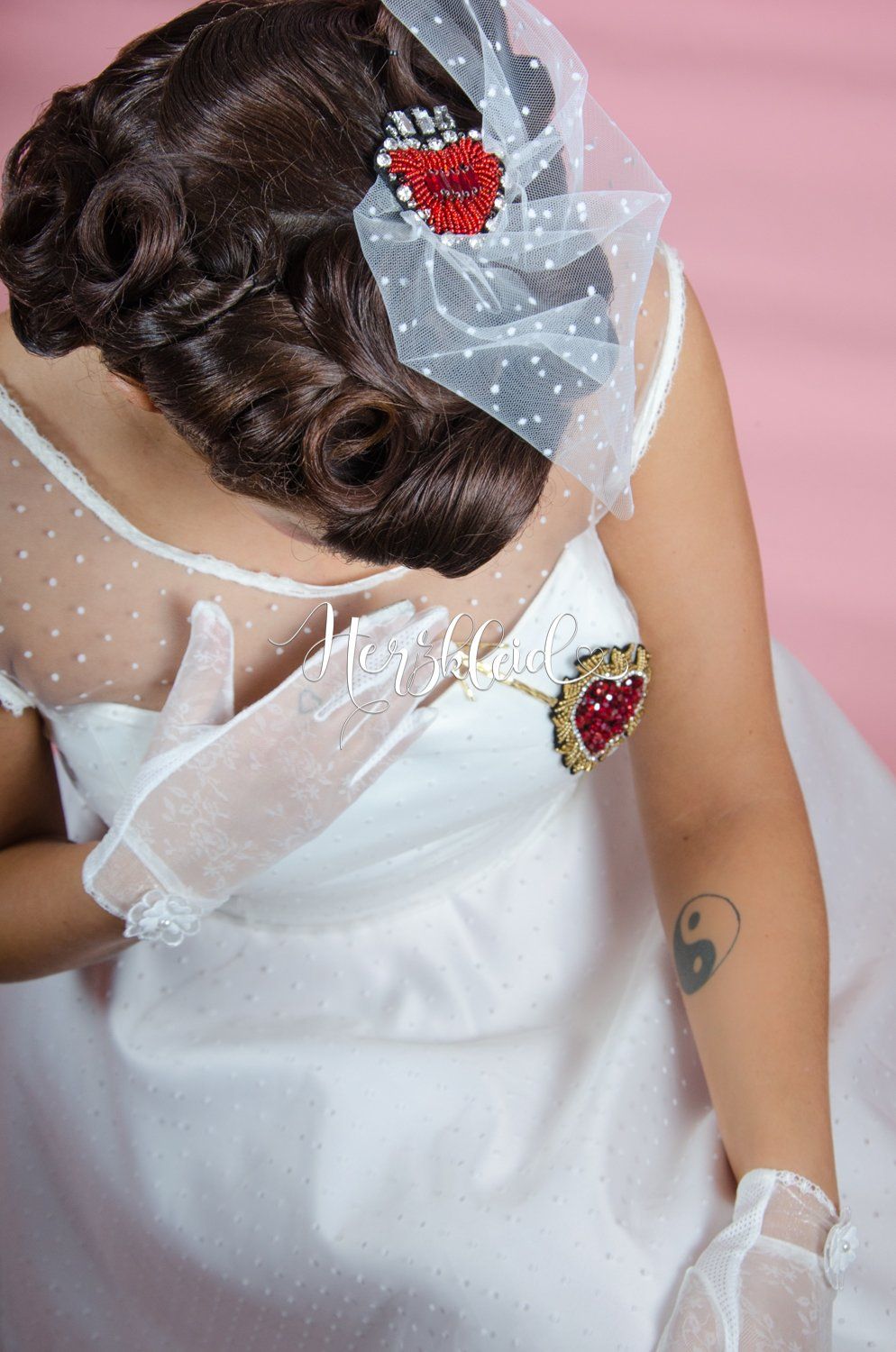 Eine Frau in einem Brautkleid trägt einen Schleier und Handschuhe.