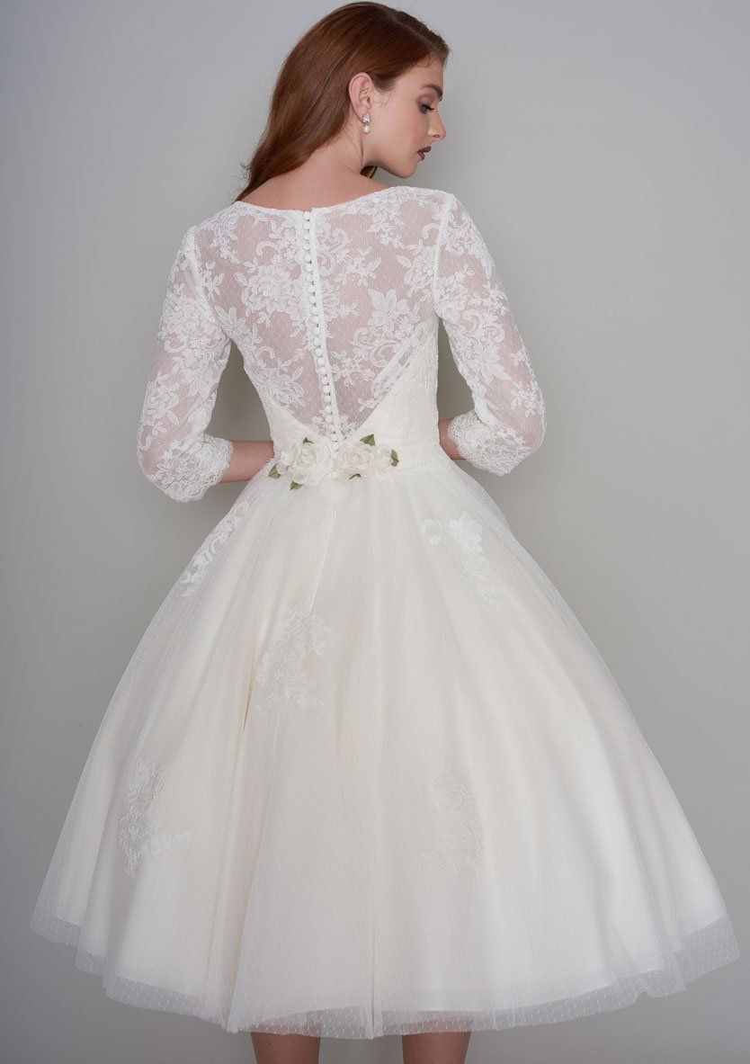 Der Rücken einer Frau, die ein weißes Brautkleid mit langen Ärmeln trägt.