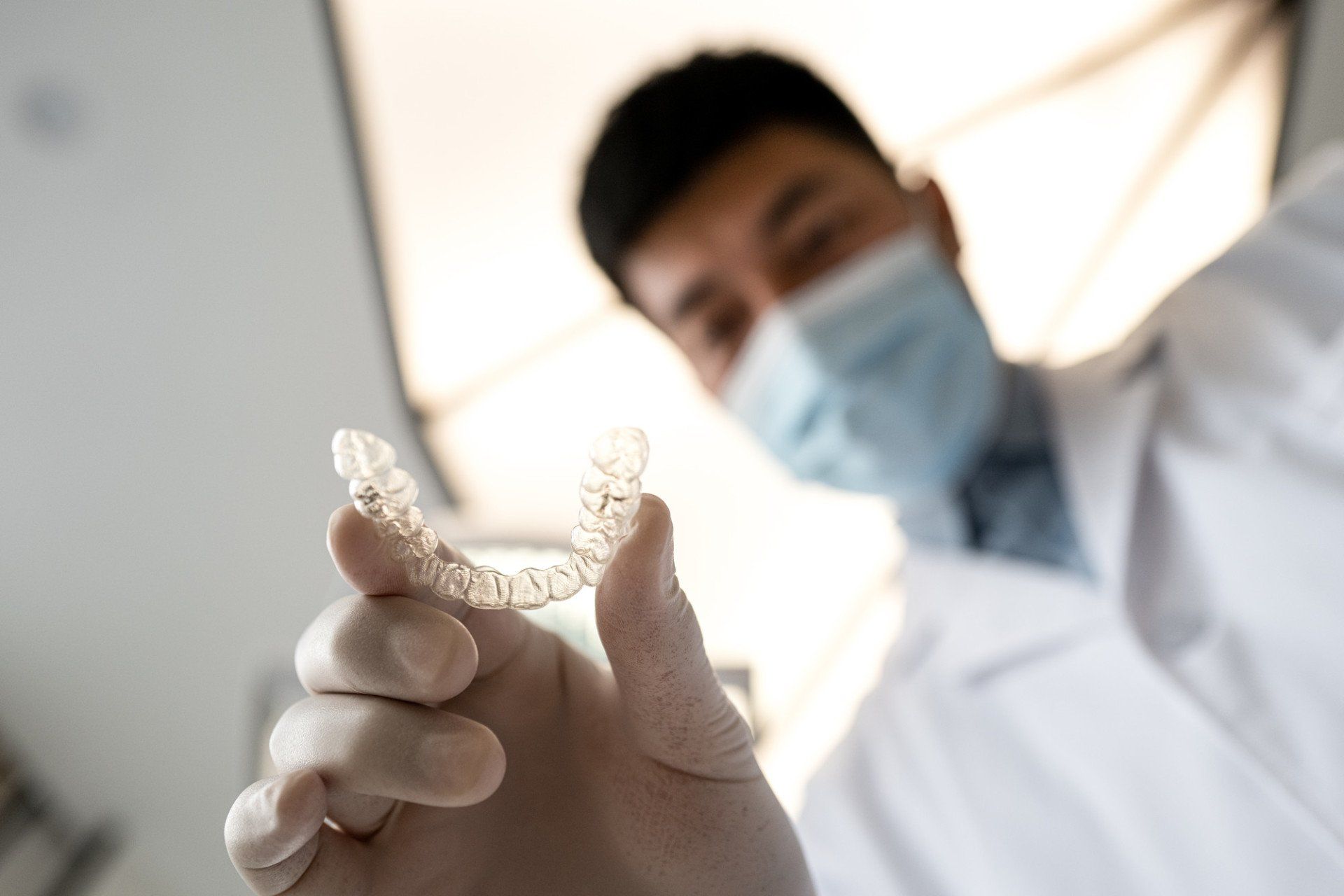 dentist holding clear aligner