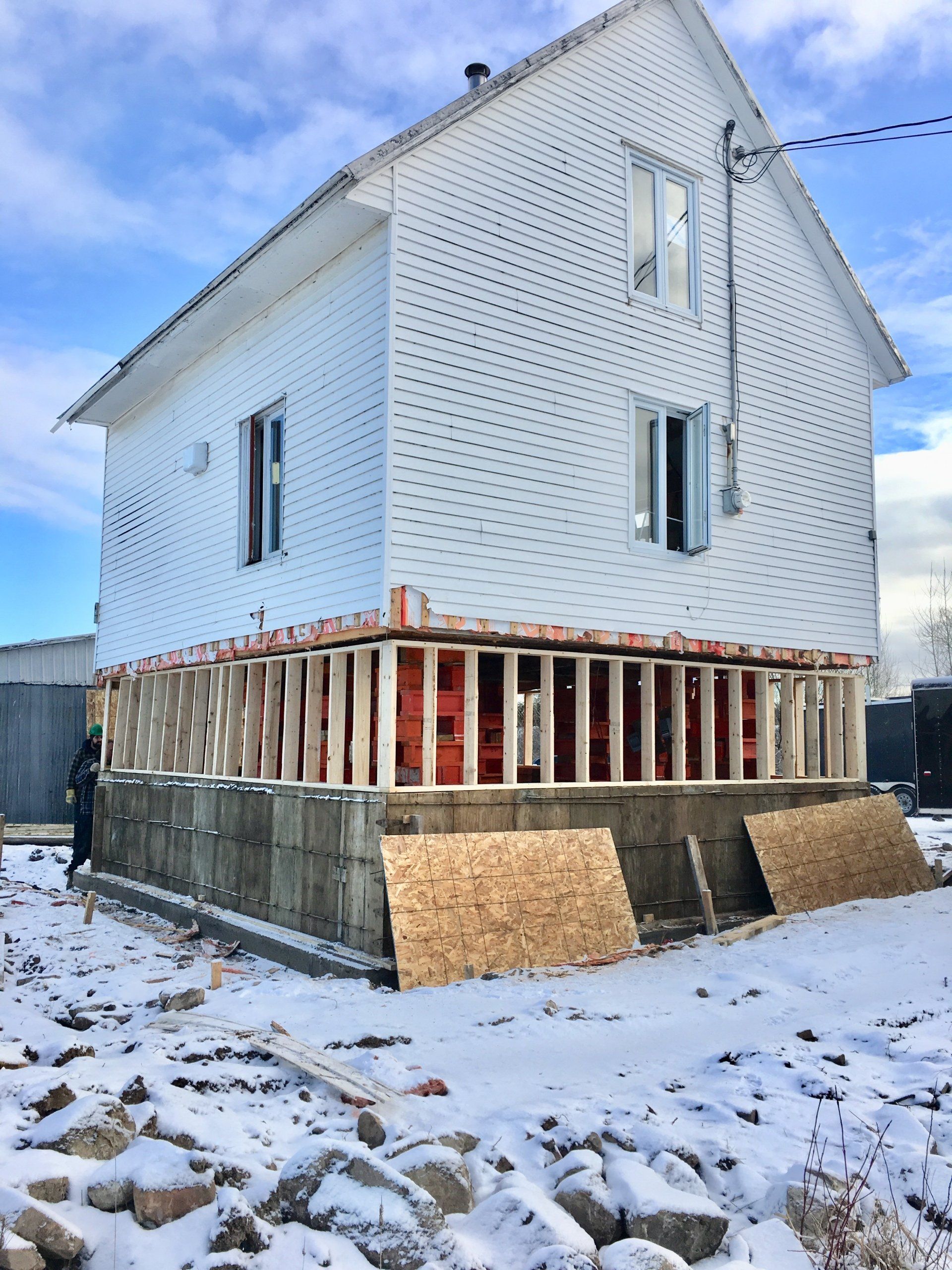 Une maison blanche est en construction dans la neige.