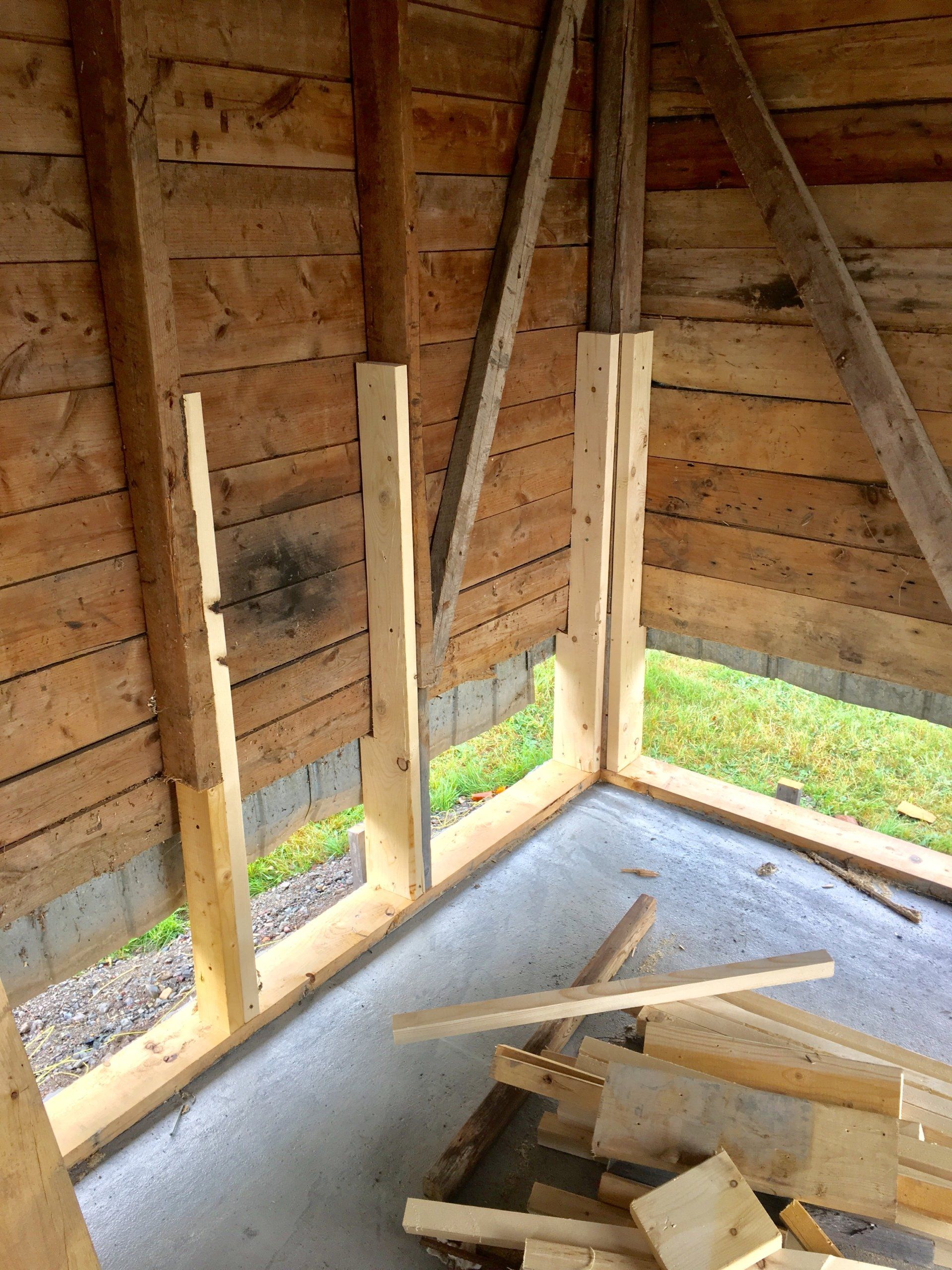 Un bâtiment en bois avec un sol en béton et quelques fenêtres