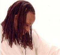 A woman with dreadlocks is wearing a white shirt