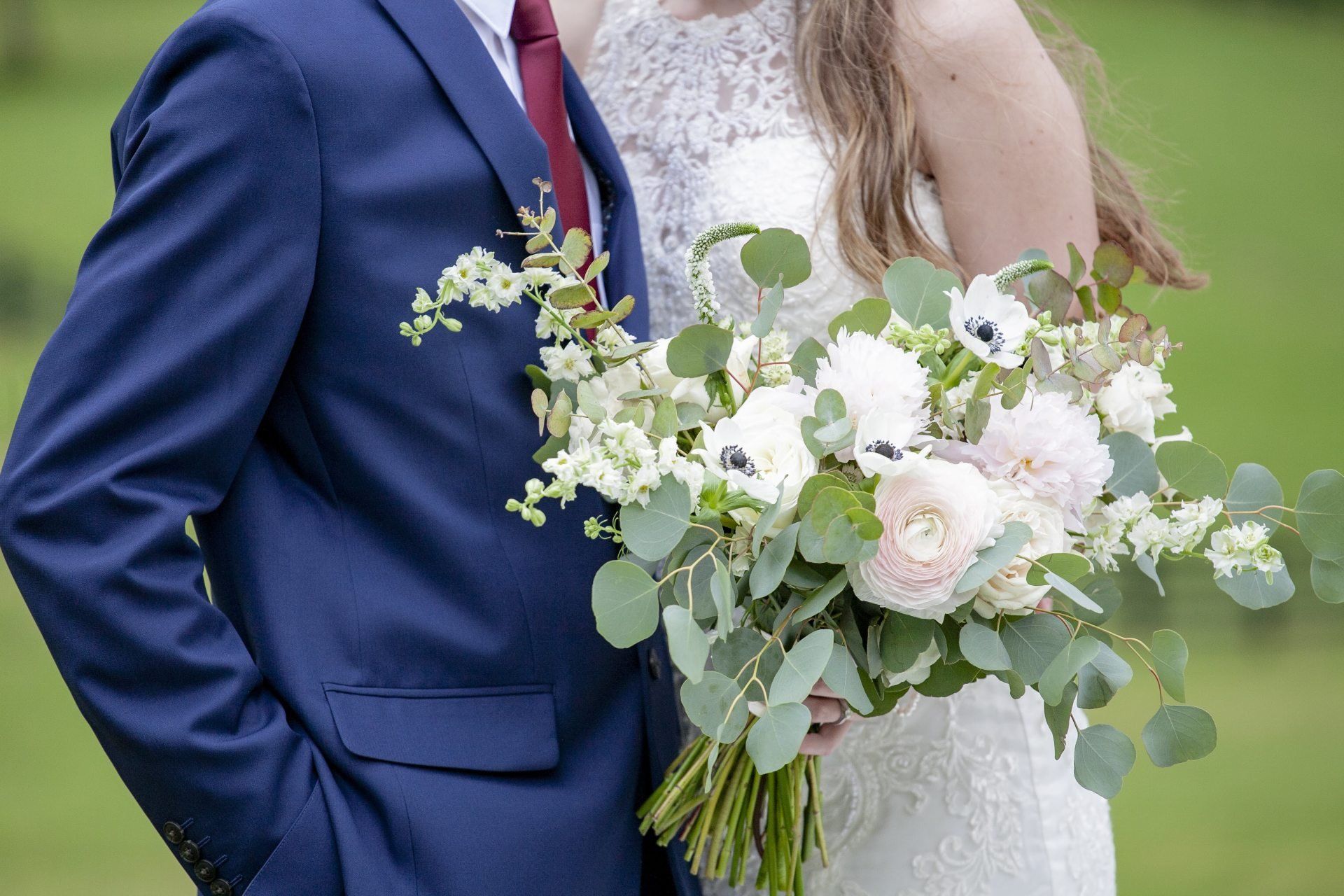 Bride and groom with a white and eucalyptus wedding bouquet outdoors