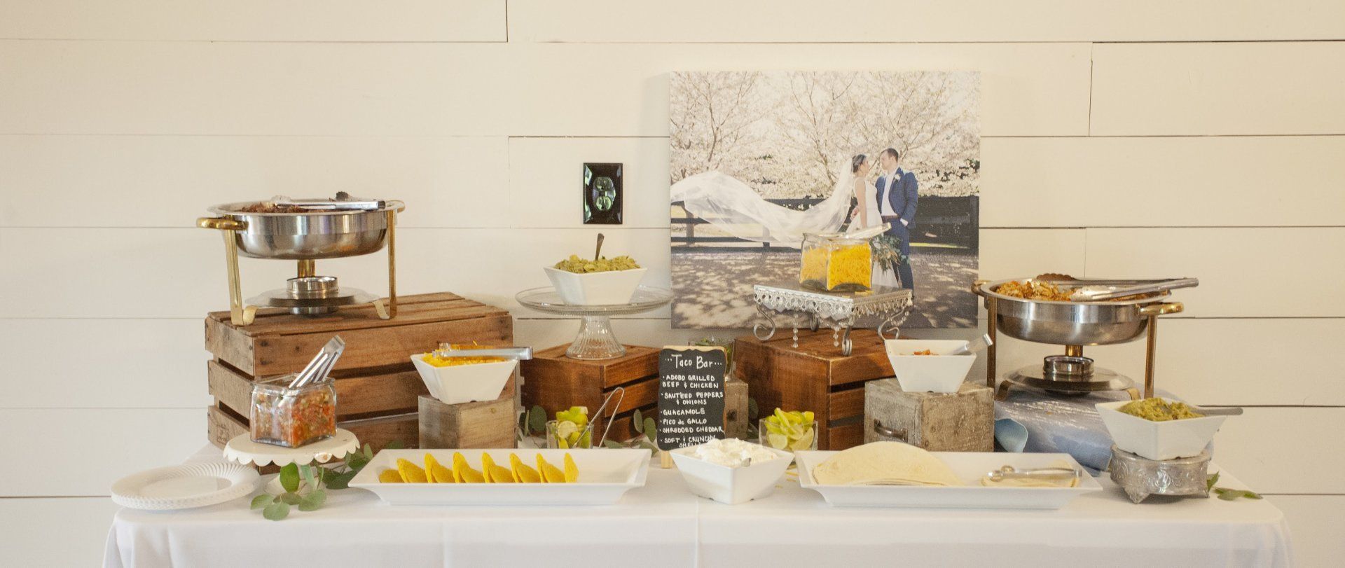 Elegant dessert buffet with cakes, pastries, fruit, and tiered trays on a white table