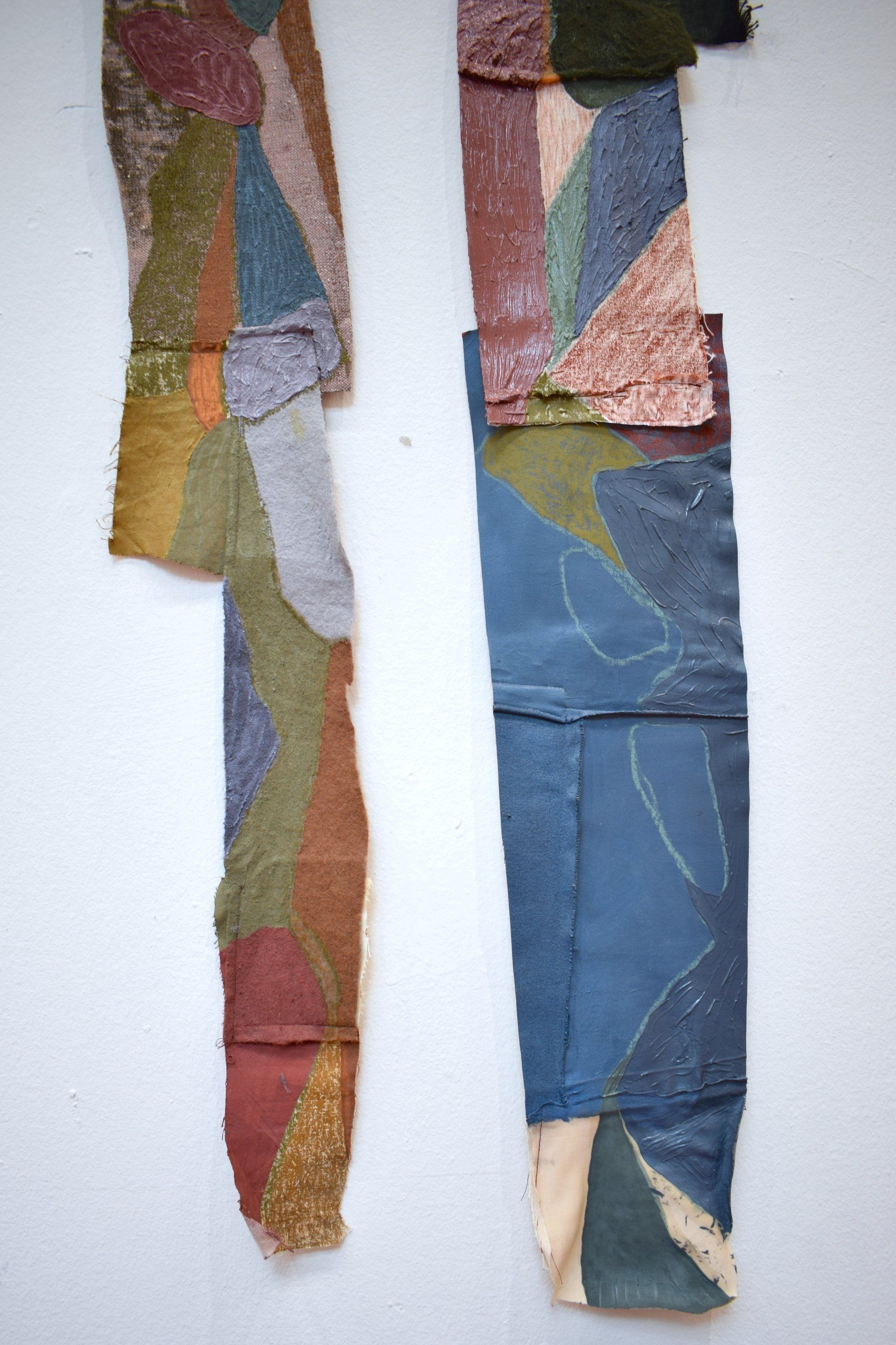 colourful paintings hanging on white gallery wall