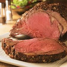 A large piece of roast beef is sitting on top of a white plate.