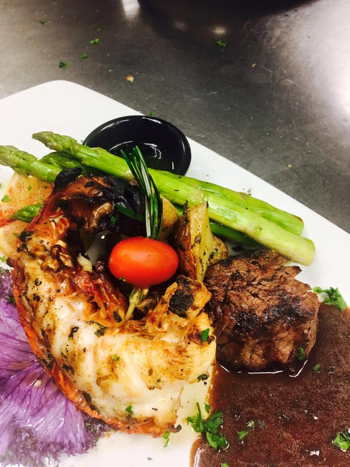 A white plate topped with meat vegetables and sauce