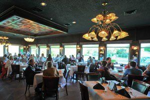 A group of people are sitting at tables in a restaurant.