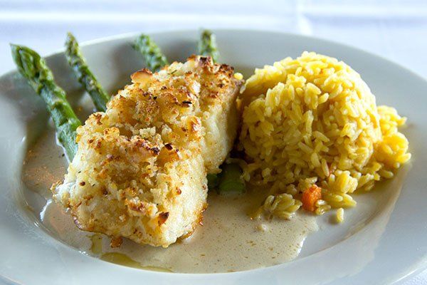 A plate of food with rice and asparagus on a table.