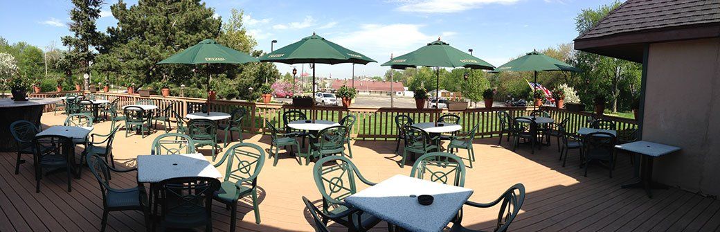 A patio with tables and chairs and umbrellas on a sunny day.