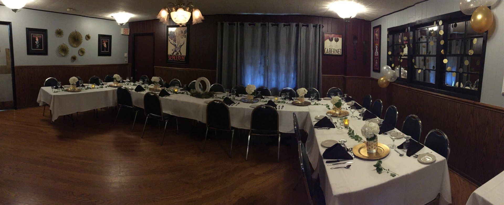 A large room with tables and chairs set up for a party.