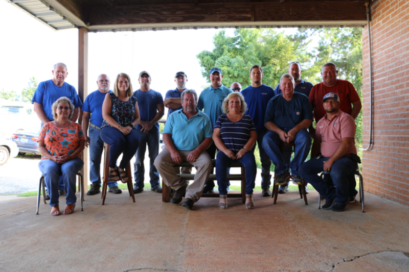 A group of people are posing for a picture under a canopy.