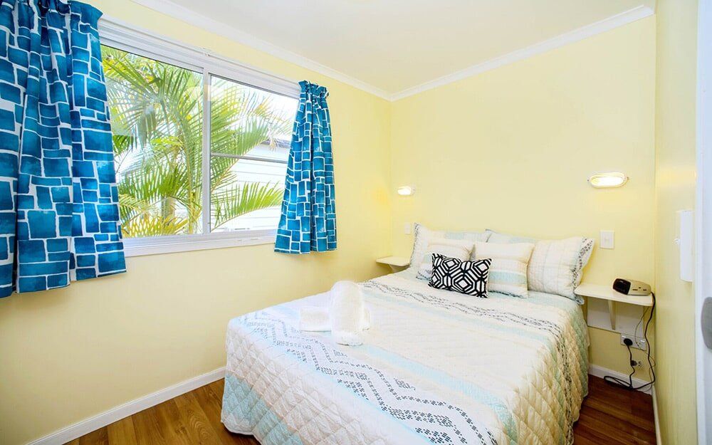 Deluxe Cabin Bedroom — Caravan Park in Woombah, NSW Deluxe Cabin Bedroom — Caravan Park in Woombah, NSW