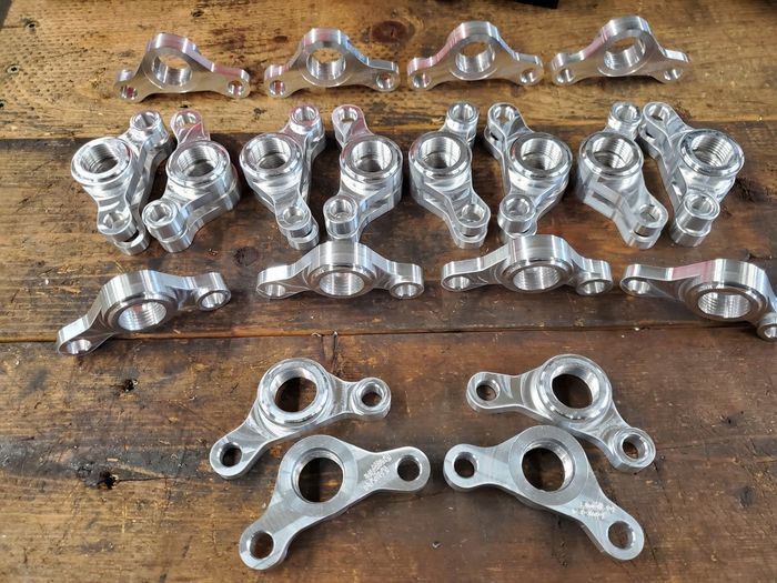 A bunch of metal parts are sitting on a wooden table.