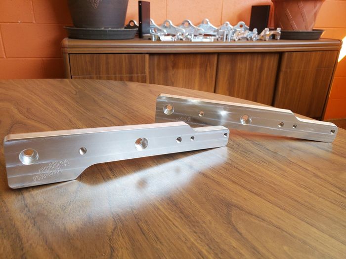 Two metal pieces are sitting on a wooden table.