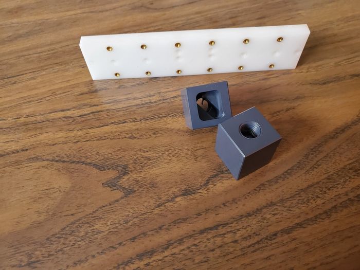 A piece of plastic with holes in it is sitting on a wooden table.