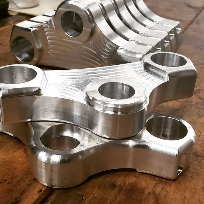 A bunch of metal pieces are stacked on top of each other on a wooden table.
