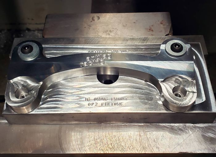 A machine is cutting a piece of metal that looks like a car