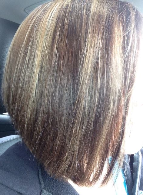 A woman with short brown hair is sitting in a car.