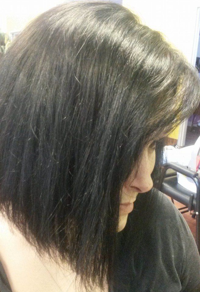 A woman with black hair is sitting in a chair.