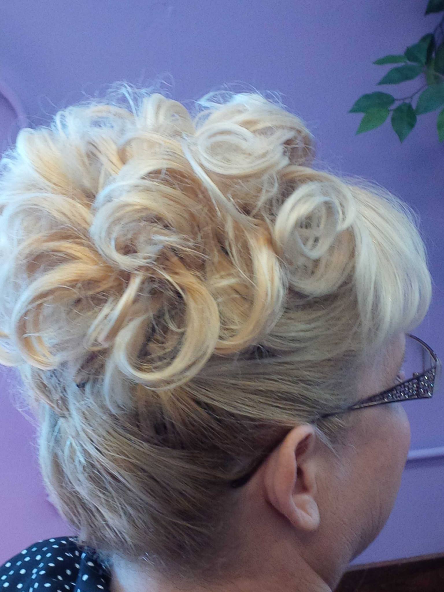 A woman wearing glasses has her hair in a bun.