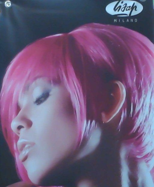 A close up of a woman's face with pink hair.