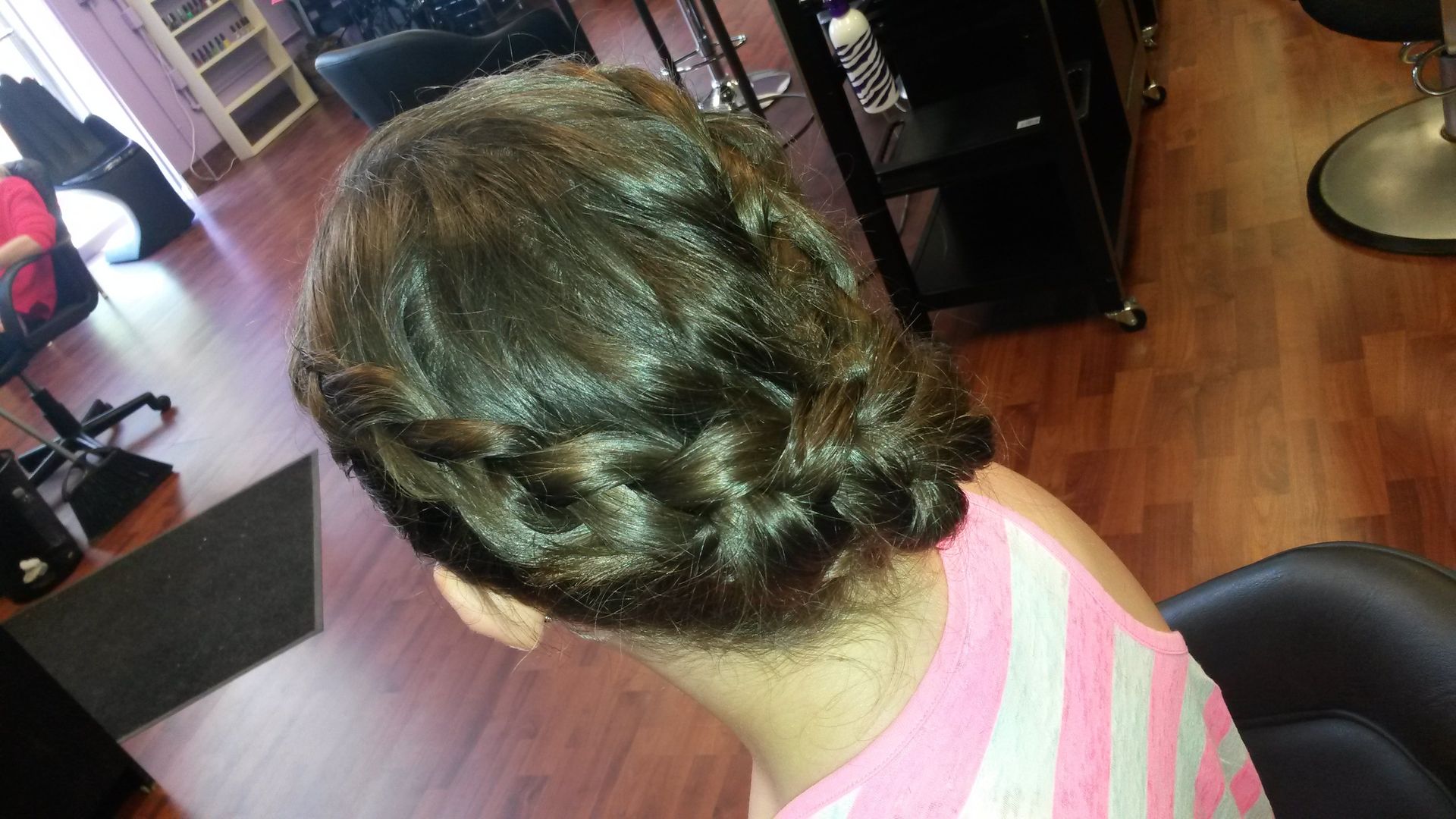 A woman is sitting in a chair with her hair in a bun.