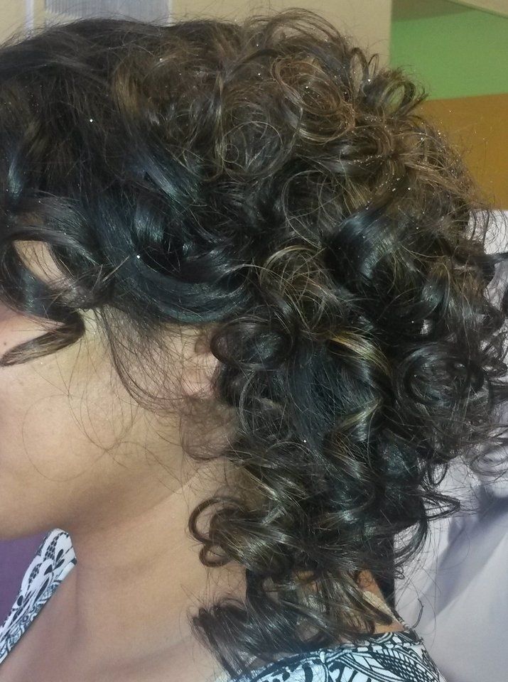 A close up of a woman's curly hair in a bun.