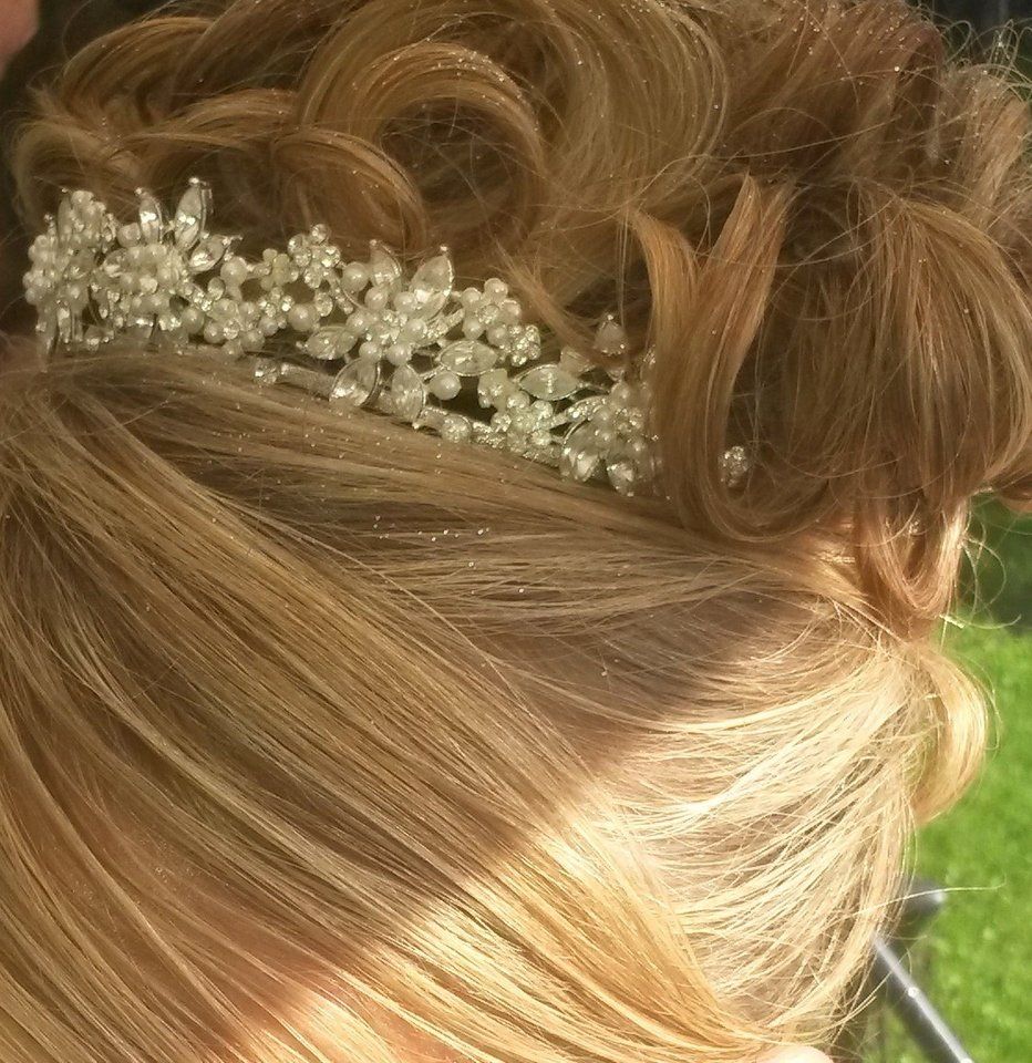 A close up of a woman's hair with a pearl comb in it.