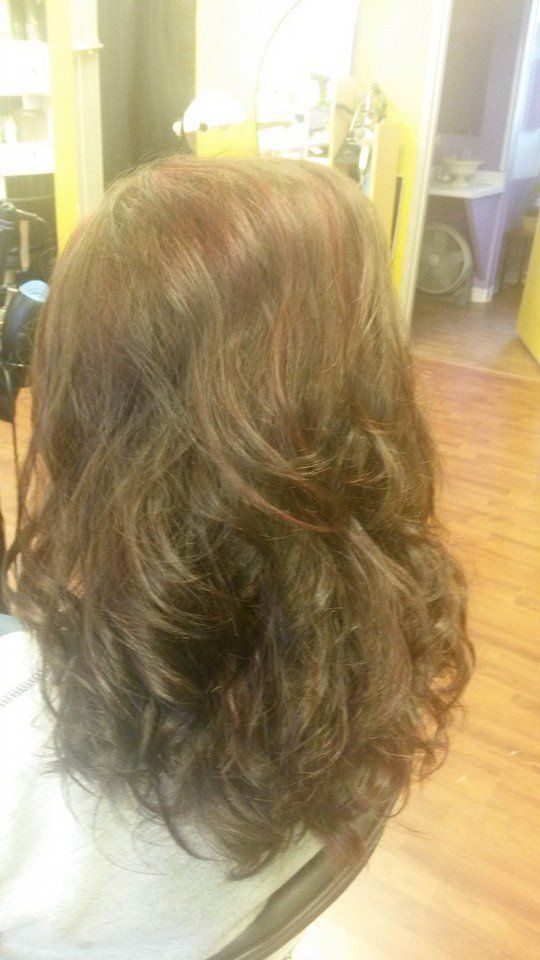 A woman is sitting in a chair in a salon.