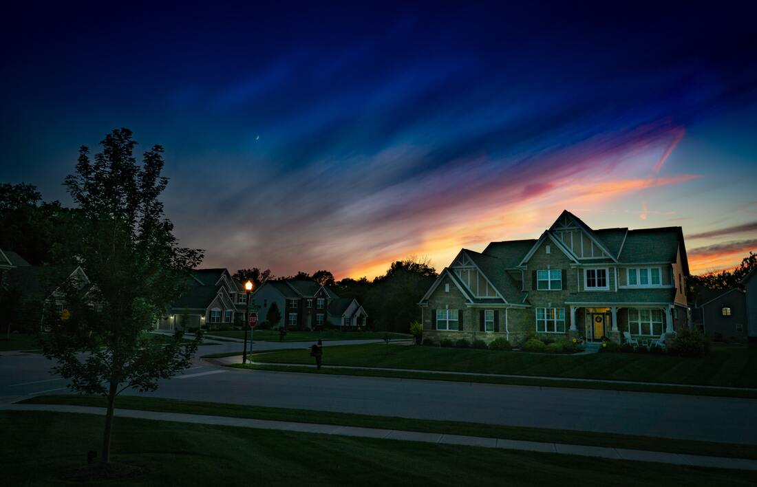 A brand new residential neighborhood at sunset with freshly paved asphalt roads.