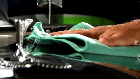 A person is washing a pair of shoes in a sink.
