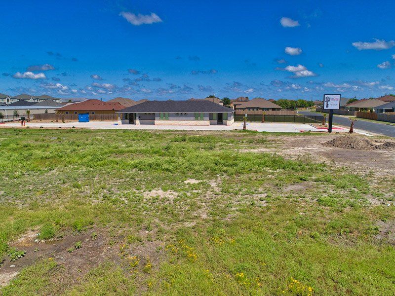 An Aerial View Of A Large Grassy Field With A House In The Background - Corpus Christi, TX - Lock & Key Storage