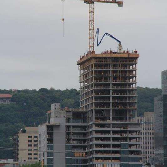 A large building under construction with a crane on top of it.